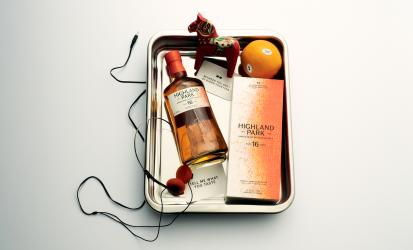 A bottle of Highland Park Between You & I, laid in a metal box