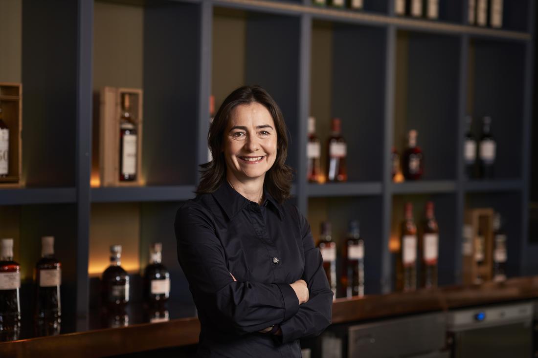 Portrait of Suzy Smith standing in front of a bar with Edrington bottles behind her