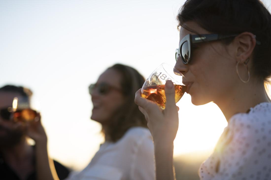 Two woman pictured side on sipping a Brugal 1888 outside