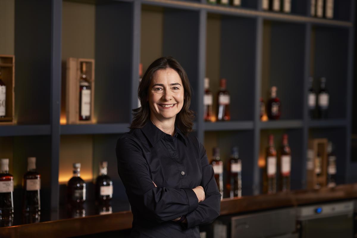 Portrait of Suzy Smith standing in front of a bar with Edrington bottles behind her