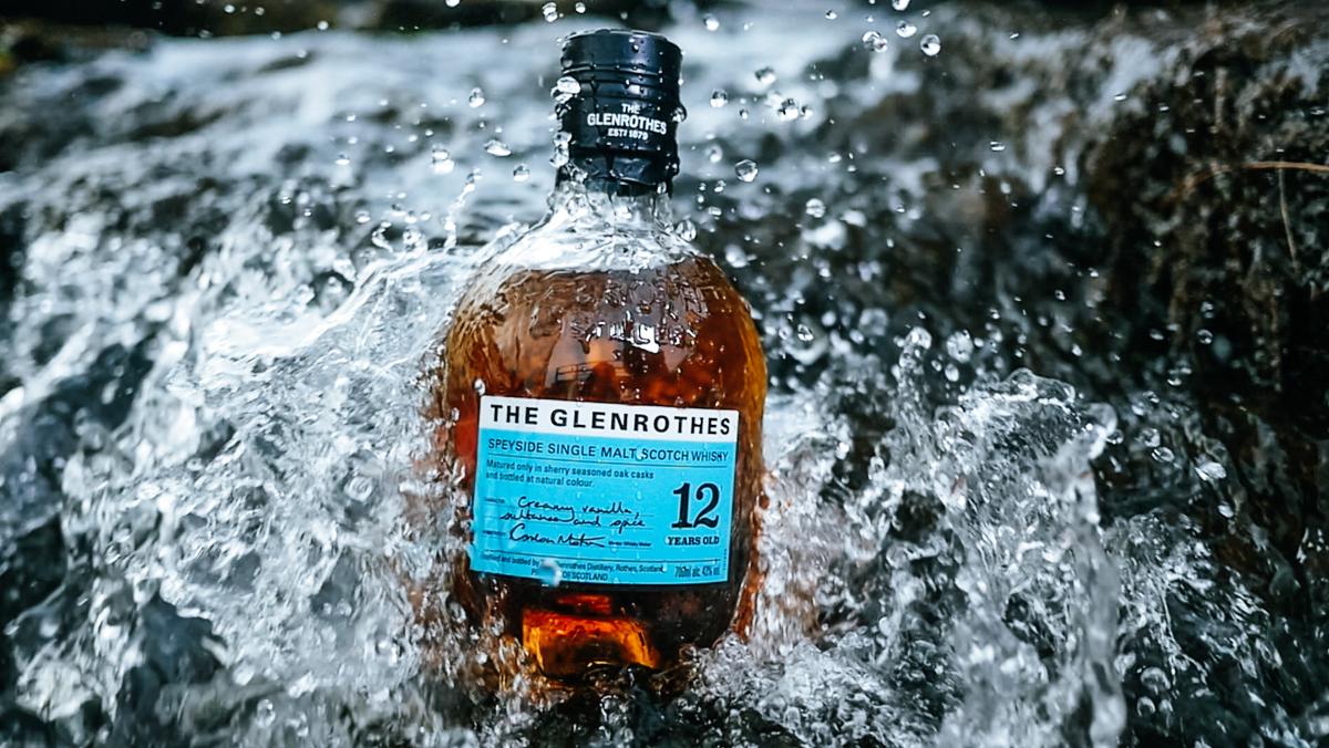 Bottle of 12 Year Old The Glenrothes from the Aqua Collection in front of a waterfall