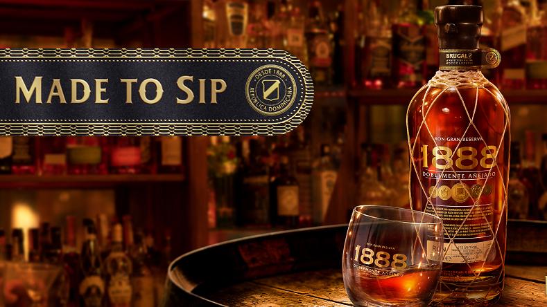 Brugal 1888 bottle on top of cask in front of back bar with Made to Sip tagline