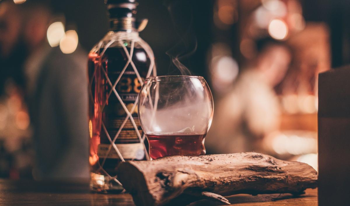 Bottle of 1888 and a rum glass on top of a bar