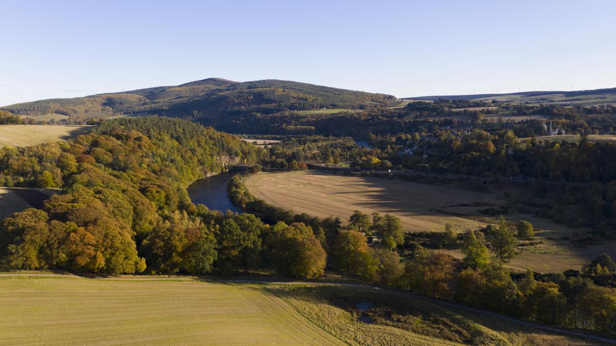 Drone shot of River Spey surrounded by fields and trees