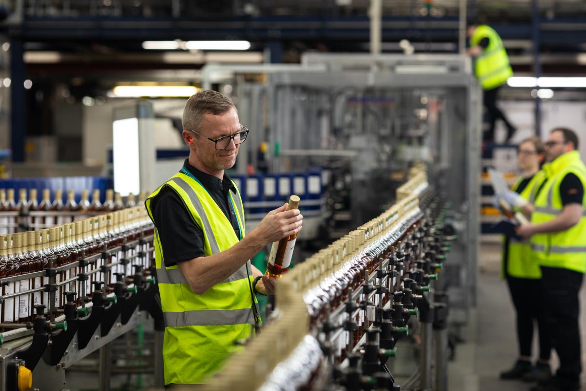 A colleague inspecting a bottle of The Macallan on the production line