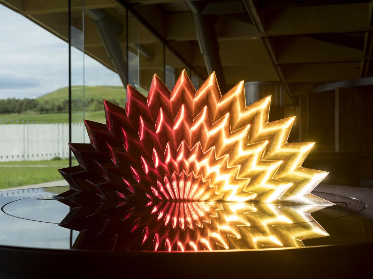 A crystal display in the shape of a peacock tail showing shades of The Macallan
