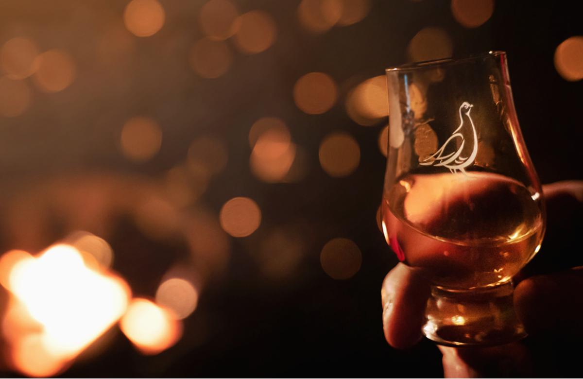 Branded The Famous Grouse dram glass with whisky in it