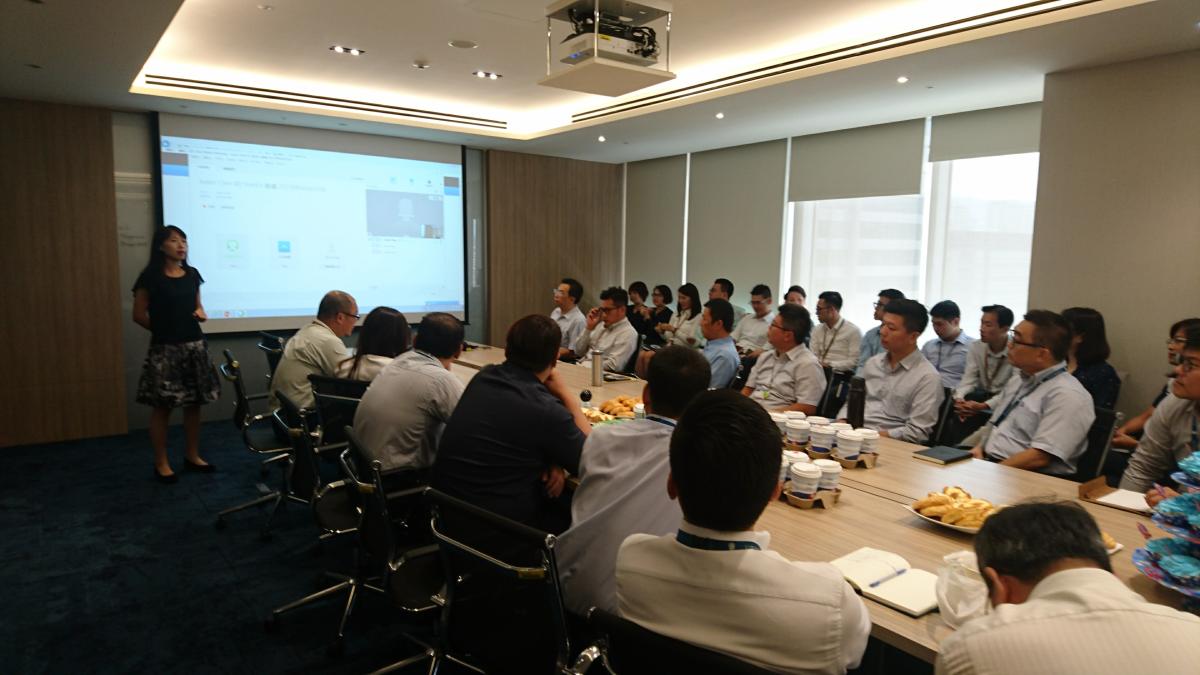 A number of people around a table in a meeting