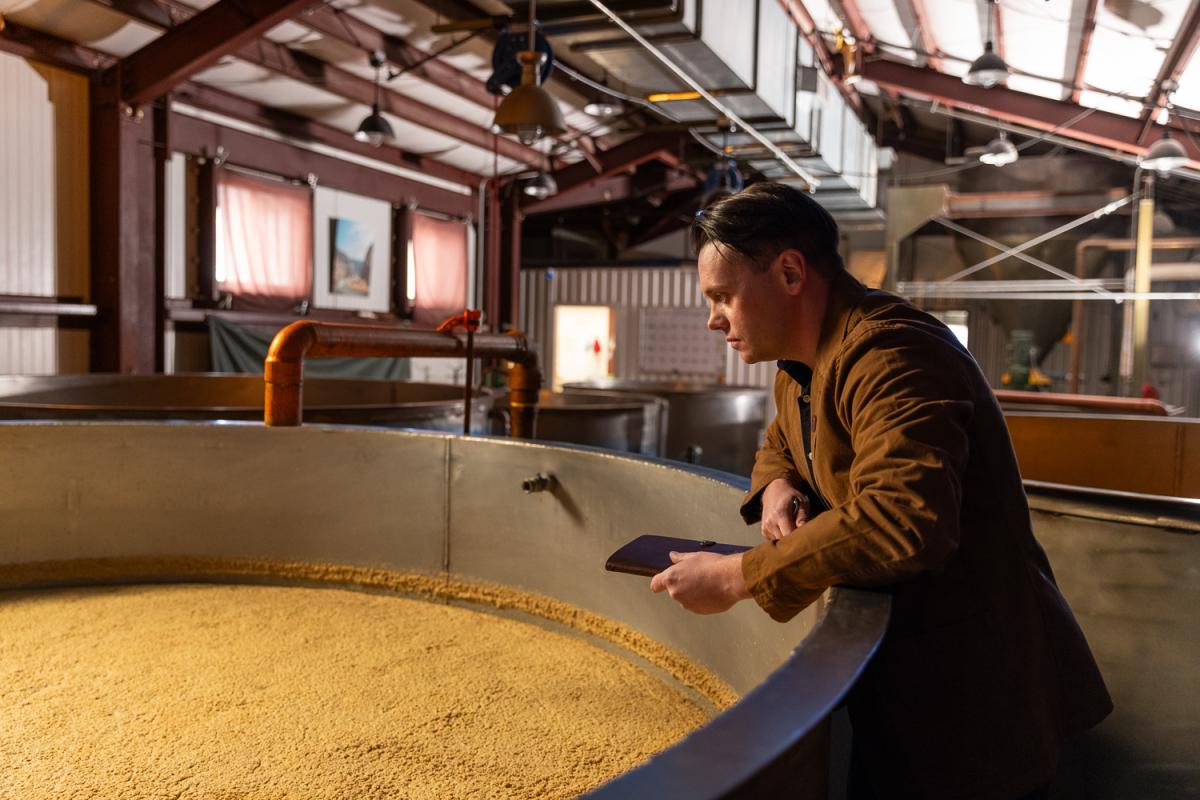 Master blender at Wyoming Whiskey Distillery inspecting a mash 