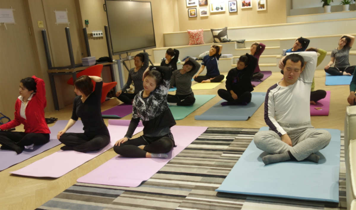 Colleagues in China participating in a yoga wellness session