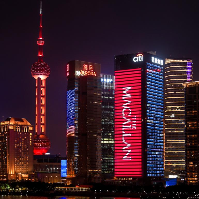 quare image of the Shanghai skyline lit up at night with The Macallan branding projected onto the side of a skyscraper