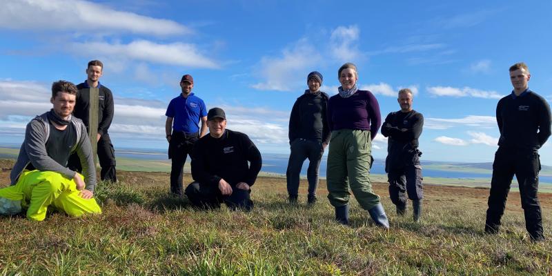 Highland Park's distillery manager Marie Gulliver and 7 of her team on a hilltop in Orkney 